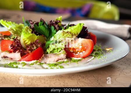 Grüner Salat mit Tomaten und geräuchertem Schinken Stockfoto