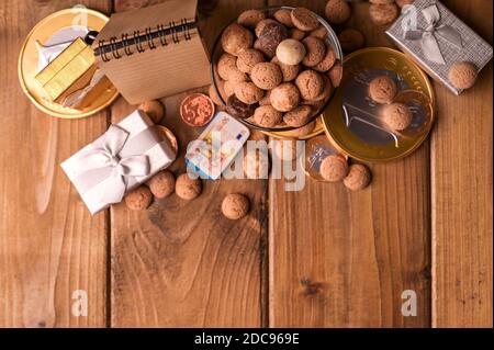 Blick von oben. Traditionelle niederländische Urlaubspostkarte Sinterklaas. Holzhintergrund mit Kinderschuh mit Karotten für Santa's Pferd, Pepernoten und Süßigkeiten. Speicherplatz kopieren. Hochwertige Fotos. Stockfoto