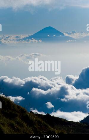 Mount Agung, der höchste Vulkan auf Bali, steigt hoch über den Wolken vom Campingplatz am ersten Tag des dreitägigen Mount Rinjani Trek, Lombok, Indonesien, Asien Stockfoto