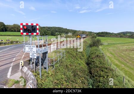 Silverdale automatische Halbschranke ( AHB ) Bahnübergang Lancashire mit einem Zug der Northern Rail Klasse 156 Annäherung Stockfoto