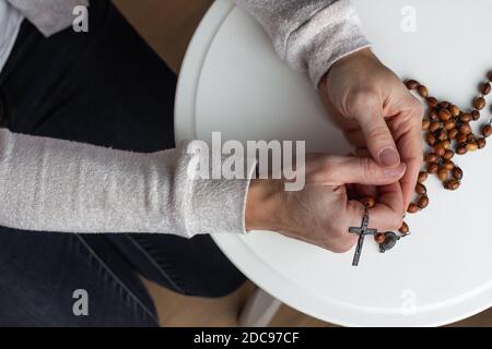 Frauen Hände halten Holz katholischen Rosenkranz im Gebet Stockfoto