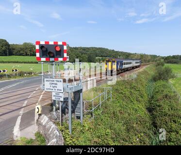 Silverdale automatische Halbschranke ( AHB ) Bahnübergang Lancashire mit einem Zug der Northern Rail Klasse 156 Annäherung Stockfoto