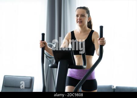 Frauen Training Auf Elliptical Trainer Zu Hause Stockfoto