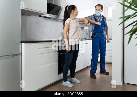 Reparatur Man Oder Handyman Service In Gesichtsmaske Ellenbogen Bump Stockfoto