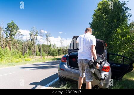 Man nahm ein Skateboard aus dem Kofferraum eines Auto an der Straße mit einem sonnigen Sommertag geparkt Stockfoto