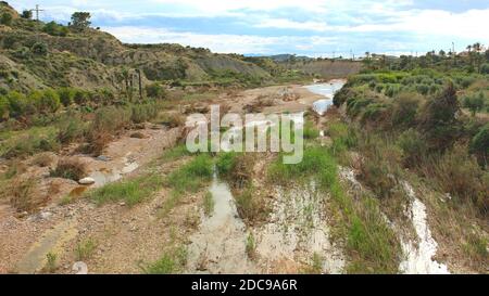 Ein fast ausgetrocknetes Flussbett am Fuße der sierras im Südwesten der Provinz Alicante, Spanien. Dieser Wasserlauf ist Teil des Canal del Taibilla. Stockfoto