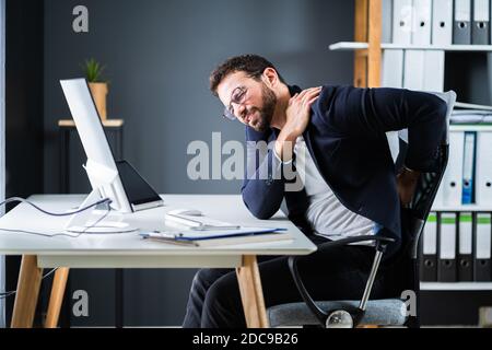 Junger Mann Mit Rückenschmerzen. Falsche Bürohaltung Stockfoto