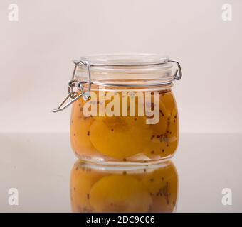 Glas von hausgemachten Pfirsichen in Beizen bewahren Schuss vor einem weißen Hintergrund im Studio. Als Weihnachtsgeschenk gemacht. Stockfoto