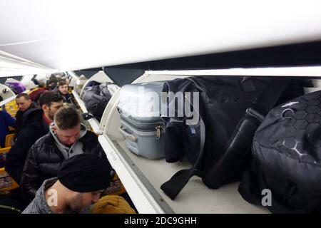 27.01.2019, Schönefeld, Brandenburg, Deutschland - Personen in einer Ryanair-Flugzeugkabine, die ihr Handgepäck vor dem Abflug verstauen. 00S190127D796CAROEX.JP Stockfoto