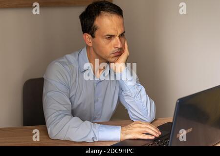 Reifer Mann gelangweilt vor seinem Laptop. Stockfoto