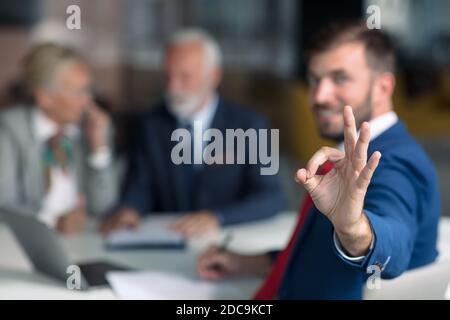 Positiv gealtertes Paar, das mit Versicherungsagent berät Stockfoto