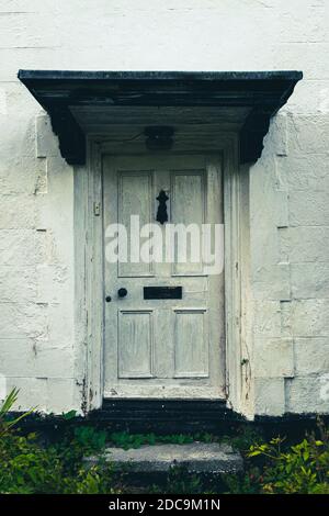 Schöne ländliche weiße rustikale Tür mit von Unkraut Treppen überwuchert, britische Landhaus in der Mitte des Nirgendwo. Stockfoto