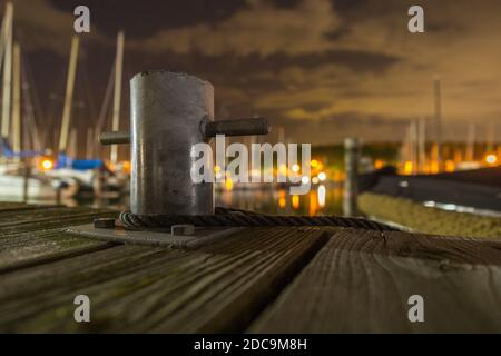 Poller auf Holzsteg mit Seil in der Nacht Stockfoto