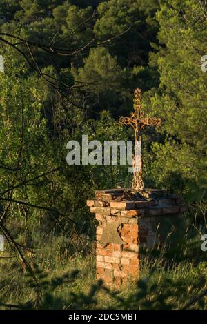 Rostiges schmiedeeisernes christliches Kreuz in der Abendsonne Stockfoto