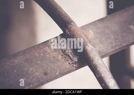 Ein selektiver Fokus aus rostig geschweißtem Metall gegen Unschärfe Hintergrund Stockfoto