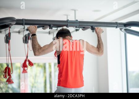 Junger dunkelhaariger Mann, der im Fitnessstudio trainiert Stockfoto