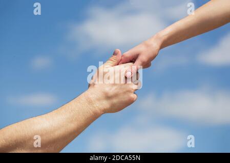 Hände von Mann und Frau, die sich gegenseitig erreichen, unterstützen. Solidarität, Mitgefühl und Nächstenliebe, Rettung. Eine helfende Hand geben. Hände von Mann und Frau an Stockfoto