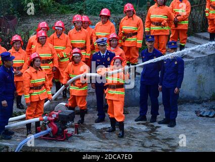 (201120) -- RONGSHUI, 20. November 2020 (Xinhua) -- Freiwillige nehmen am 19. November 2020 unter Anleitung professioneller Feuerwehrleute an einer Feuerübung im Dorf Wuying Teil, einem abgelegenen Dorf, das von der ethnischen Gruppe Miao an der Grenze zwischen der Autonomen Region Guangxi Zhuang im Süden Chinas und der Provinz Guizhou im Südwesten Chinas bewohnt wird. Da die Häuser mit dem lokalen Baustil im Dorf von einer bewaldeten Struktur unterstützt werden, wird ein Team von weiblichen Freiwilligen Feuerwehrleuten gebildet, um ihr Dorf zu schützen, da die meisten jungen und mittleren Alters Männer als Migranten ausziehen. (Xinhua/Huang Xiaobang) Stockfoto