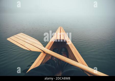 Winter-Kanufahren. Kanu fahren und paddeln auf dem nebligen See Stockfoto