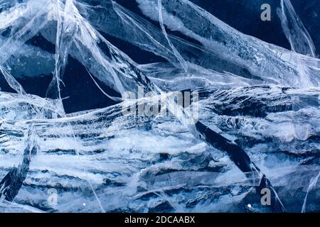 Große tiefe Risse im Eis des Sees. Blaues dickes und transparentes Eis. Horizontal. Stockfoto