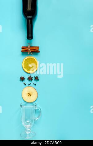 Glühwein Zutaten, Stillleben auf blauem Hintergrund. Flasche Wein, Zimtschnecken, Orangenscheiben, Apfel, Anis und Becher. Konzept kulinarische reci Stockfoto