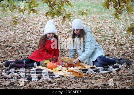 Zwei Mädchen in einem Herbstpark bei einem Picknick Stockfoto