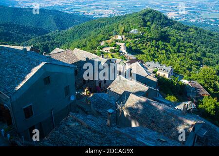 Hochwinkel Blick auf ein korsisches Dorf in den Bergen Mit Wald und Meer im Hintergrund auf einem sonnigen Tag im Sommer Stockfoto