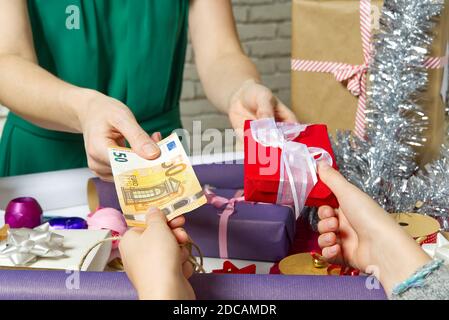 Zahlung für Geschenkverpackung bei der Verpackung mit Euro-Banknoten. Stockfoto