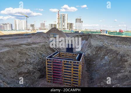 Betonstapel in Schalungsrahmen für Regenwasser und unterirdische Versorgungseinrichtungen, Pumpstationen, Kanalisation Rohre zu bauen. Anschließen eines Heizsystems an eine Konz Stockfoto