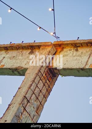 Beton- und Metallelement mit Rost und mit Lichtquellen auf einem klaren Himmel Hintergrund. Stockfoto