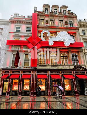 London, Großbritannien. November 2020. Menschen mit Sonnenschirmen gehen an den Weihnachtsdekorationen im Cartier-Laden vorbei.Trotz der Covid-19-Sperre, die zur Schließung aller nicht-wesentlichen Geschäfte bis mindestens 2. Dezember geführt hat, sind die berühmten Luxusjuweliers, Cartier sind bereit, ihre Kunden mit ihren traditionell schicken festlichen Dekoration ihrer New Bond Street Store zurück zu begrüßen. Kredit: Keith Mayhew/SOPA Images/ZUMA Wire/Alamy Live Nachrichten Stockfoto