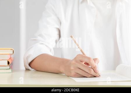 Eine Hand Geschäftsfrau, die im Büro auf Papier schreibt Stockfoto