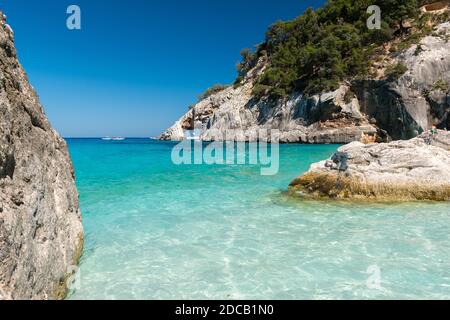 Die Küste in Cala Goloritze, berühmter Strand im Golf von Orosei (Ogliastra, Sardinien, Italien) mit einem natürlichen Bogen im Hintergrund Stockfoto