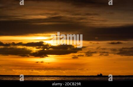 Bournemouth, Großbritannien. November 2020. Ein Fischerboot macht es Weg über Poole Bay bei Sonnenaufgang vom Bournemouth Strand an der Dorset Küste gesehen. Kredit: Richard Crease/Alamy Live Nachrichten Stockfoto