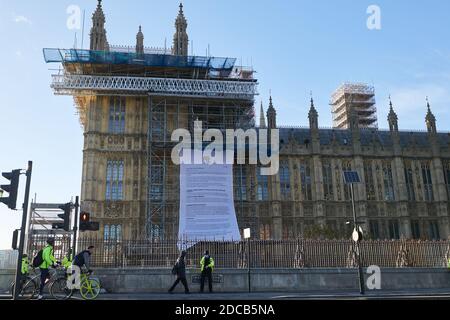 London, Großbritannien. - 12. Nov 2020: Die Polizei umringt Demonstranten der Protestgruppe Africans Rising, die ein großes Banner auf den Bauarbeiten an der Seite des Parlaments entfaltet haben. Stockfoto