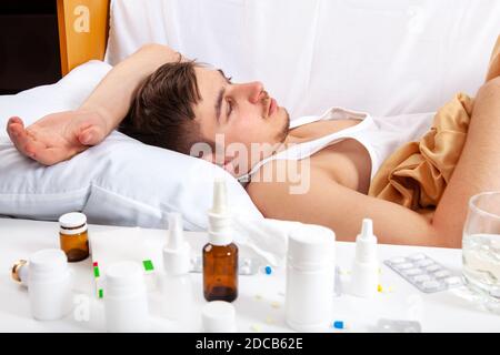 Trauriger und kranker junger Mann im Bett im Zu Hause Stockfoto
