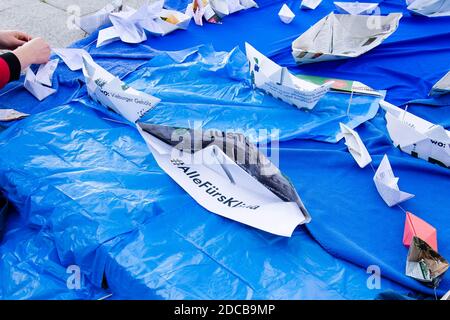 Kiel, Deutschland. November 2020. Papierboote stehen auf einer blauen Plastikfolie vor dem Kieler parlament. Die Aktion der Klimabewegung Fridays for Future will auf den steigenden Meeresspiegel aufmerksam machen und fordert bis 2035 die Klimaneutralität Deutschlands. Kredit: Frank Molter/dpa/Alamy Live Nachrichten Stockfoto