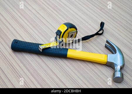 Hammer und Maßband sind Handwerkzeuge für Der Zimmermann auf Holzbrett Stockfoto