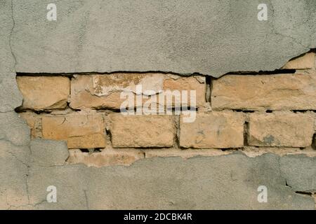 Textur der Außenwand mit abgefallener Gips. Altes Gebäude mit abfallendem Putz. Hintergrund der Ziegelwand Muster Stockfoto