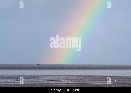 Regenbogen endet auf der Liste Reste des Wyre Light, ein 40-Fuß hohen Eisen-Schraubenstapel Leuchtturm, Morecambe Bay, Lancashire, Großbritannien Stockfoto