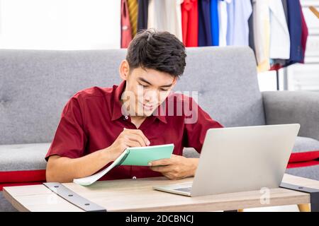 Junge asiatische männliche Online-Händler Freelance Blogger arbeitet Geschäft zu Hause mit Laptop. Social Media, Influencer und Online-Shopping-Konzept. Stockfoto