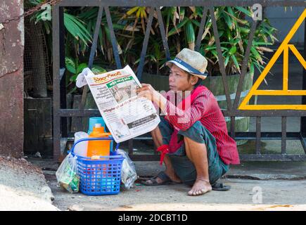 Alltag in Myanmar - junger Mann liest Zeitung in Yangon, Myanmar (Burma), Asien im Februar Stockfoto