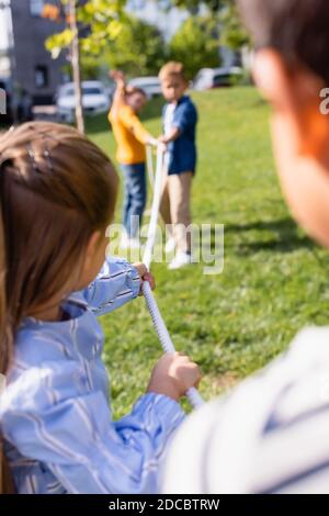 Seil in den Händen von Kindern, die an einem Tauziehen spielen Verschwommener Hintergrund im Park Stockfoto