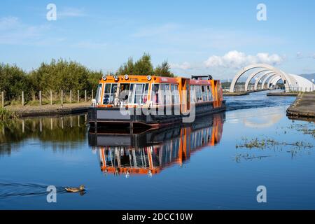 Kanalboot auf erhöhtem Abschnitt des Kanals, das die Spitze des Falkirk Wheel rotierenden Bootlift in Falkirk, Schottland, Großbritannien verlässt Stockfoto