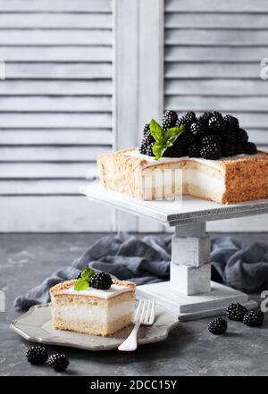 Kokosmehl Kuchen mit Sahne und Brombeeren, selektive Fokus Stockfoto