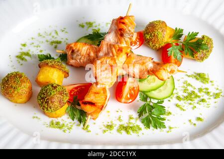 Gegrillter Lachskebab mit Tomaten, Gurken und gebackenen Kartoffeln Mit Gewürzen Stockfoto