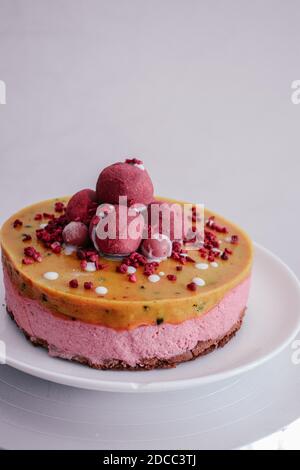 Roher veganer Himbeerkuchen mit Beerentrüffel verziert. Mangofüllung Gelee vegetarisch Cashew Sahne Käsekuchen glutenfrei. Laktosezucker freie Wüste Stockfoto