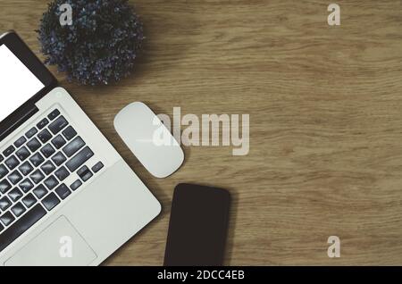 Moderner Büroschreibtisch mit Bürobedarf Computer Laptop, Smartphone, Baum und Maus auf Draufsicht und Kopierraum.Flat Lay Business Konzept Schreibtisch Stockfoto