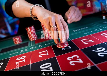 Frau spielt am Roulettetisch im Casino Stockfoto