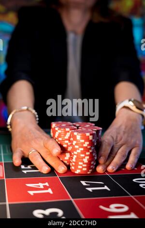 Frau spielt am Roulettetisch im Casino Stockfoto